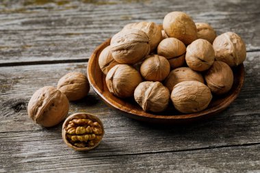 Çiğ cevizli tabak ve ahşap masa kabuğu..