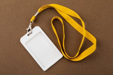 Üzerinde çalışan kimliğin adı yazan etiket. Çalışanının kimliği. Kahverengi arkaplanda ipleri olan harita simgeleri.