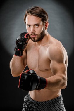 Boks eldivenli bir adam. Siyah arka planda boks yapan bir adam. Sağlıklı yaşam tarzı kavramı.