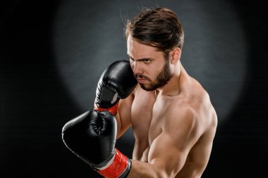 Boks eldivenli bir adam. Siyah arka planda boks yapan bir adam. Sağlıklı yaşam tarzı kavramı.