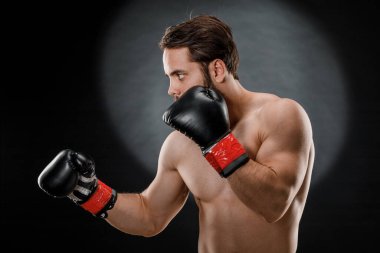 Boks eldivenli bir adam. Siyah arka planda boks yapan bir adam. Sağlıklı yaşam tarzı kavramı.