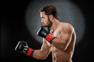 Boks eldivenli bir adam. Siyah arka planda boks yapan bir adam. Sağlıklı yaşam tarzı kavramı.