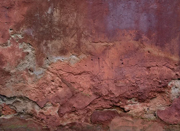 Old red wall with broken plaster. Grunge background