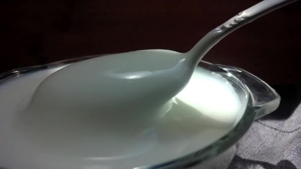 酸奶在桌子上 盘子里的酸奶 勺子在酸奶油 厚奶油 适当的营养 健康食品 — 图库视频影像