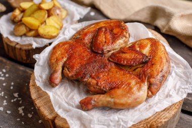 Tavuk tütün ve patates üzerinde ahşap spilah süsleyin. Rustik natürmort. Yakın çekim.