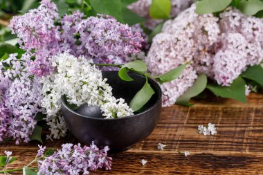 Lila beyaz ve pembe ve mor güzel çiçekler. Natürmort ahşap arka plan üzerinde.