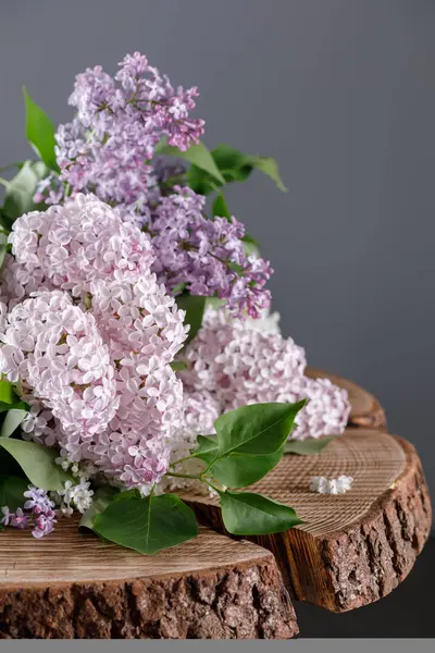 Güzel bir ahşap masa testere üst üzerinde leylak. Yumuşak gölgeler güzel çiçekler. Natürmort ahşap arka plan üzerinde.