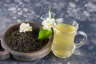 Serinletici içecek bir cam fincan. Yasemin yeşil çay. Taze çiçekler ile natürmort.