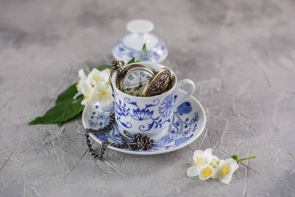 Керамическая чашка зеленого чая с жасмином и красивые часы на цепи внутри . — стоковое фото