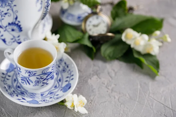 Роскошная чашка чая с зеленым чаем и жасминовыми цветами . — стоковое фото