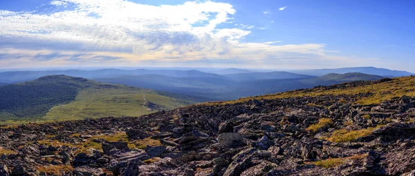 View of the Ural Mountains. Stunning panorama of the Northern Urals. Kurmnik, valleys and blue sky with beautiful clouds before the rain. Journey.