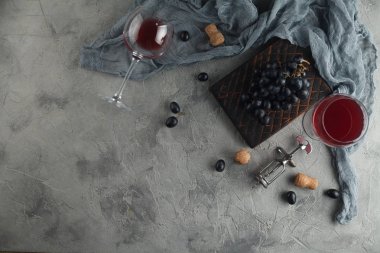 Kırmızı şarap cam kadehler vintage tirbuşon ile içinde. Dokulu gri bir arka plan üzerinde. Metin için yer ile üstten görünüm.