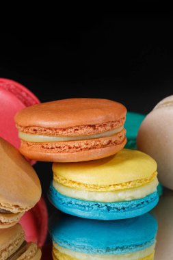 Portre siyah arka plan üzerinde renkli pastel macaroons. Tatlı macarons.