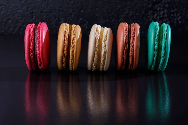 Bunte Macarons Dessert Pastellfarben Auf Schwarzem Hintergrund Einer Reihe Ausgesetzt — Stockfoto