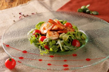 Deniz ürünleri Sezar salata karides, kruton, salata yaprağı, parmesan peyniri ve domates ile. Natürmort Tekstil ahşap bir zemin üzerine.