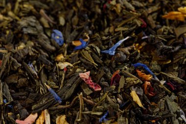Sencha yeşil çay ve peygamber çiçeği çiçek ve çilek dilimleri ile siyah çay karışımı. Kuru meyve yaprak doku arka plan. Makro. Üstten görünüm.