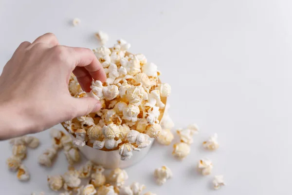 Nimmt Eine Hand Ein Popcorn Aus Einem Papiereimer Auf Weißem — Stockfoto