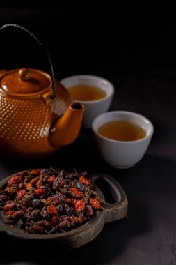 Çay demleme işlemi. Çay töreni, bardak taze demlenmiş Kuşburnu içki, karanlık ruh. Yakın çekim.