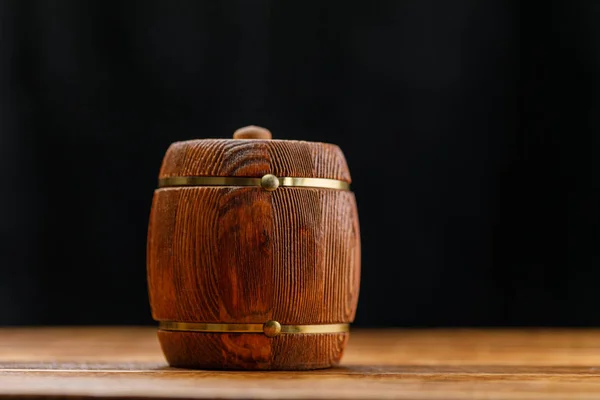 Handmade keg with honey on a wooden table on a dark background. Close-up.