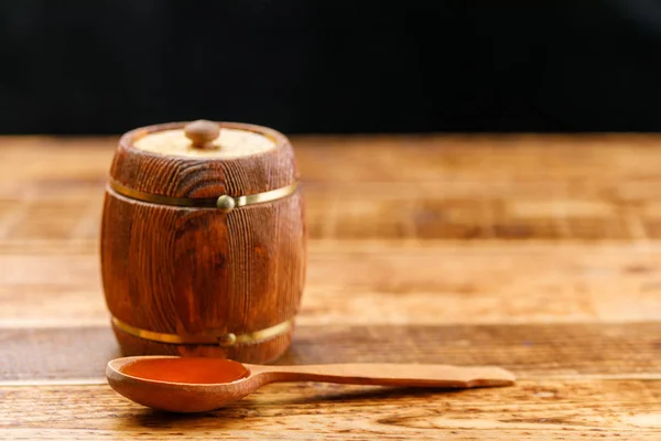 Closed keg with honey and wooden spoon on a wooden table. Barrel. Space under the text. Copy space. Close-up.