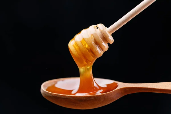 木のスプーンは 新鮮な香りの良い蜂蜜とスプーン櫛でいっぱい クローズ アップ マクロ — ストック写真