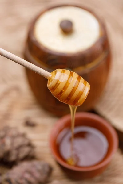 蜂蜜スプーン木製の樽型の背景に新鮮な香りの良い蜂蜜をすくいします クローズ アップ — ストック写真