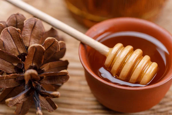 木製の背景の上に新鮮な香りの良い蜂蜜をボウルにはちみつスプーン クローズ アップ — ストック写真