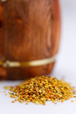 Bal ve polen beyaz zemin üzerinde bir saçılma varil. Yakın çekim. İzole.