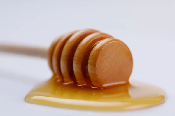 Holzlöffelstange Mit Einem Tropfen Köstlichen Flüssigen Honigs Auf Weißem Hintergrund — Stockfoto