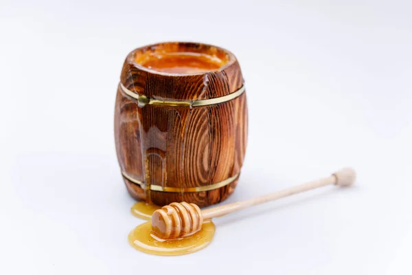 白い背景の上に蜂蜜のドロップで樽と蜂蜜スティックから流れる新鮮な蜂蜜 分離されました — ストック写真