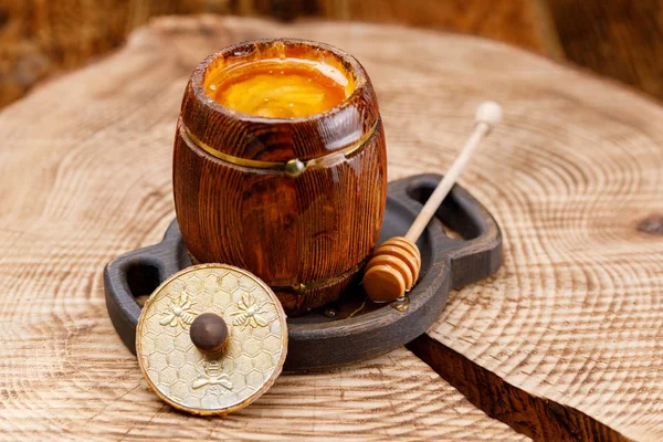 Açık varil ile bir güzel kokulu sıvı bal ve bal çubuğa içindeki bir ahşap gördüm. Yakın çekim.