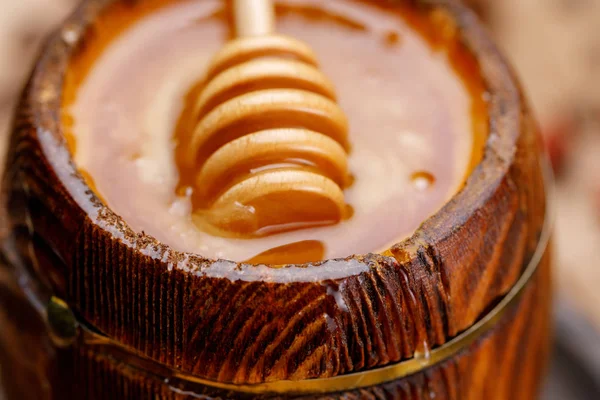 樽とそれに没頭して木の棒でおいしい新鮮な蜂蜜 クローズ アップ — ストック写真