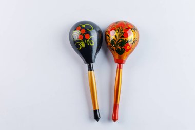Two spoons with a traditional pattern. Wooden spoons with floral ornament in traditional folk Russian Khokhloma style on a wooden background. Top view.