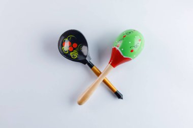 Geleneksel Rus halk tarzı ve beyaz bir arka plan üzerinde geleneksel bir desen ile Meksika Marakas çiçek süsleme tahta kaşıkla. Rusya-Meksika mutfağının tanıtımı için. Üstten görünüm.