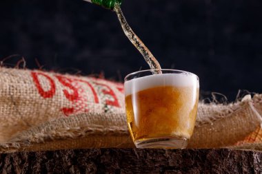 Light bira Ahşap testere bir cam Kadehi ayakta içine dökülen. Yakın çekim.