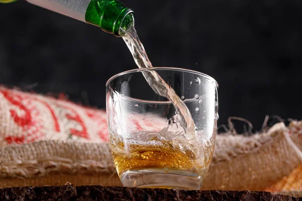 Light beer pouring into a glass goblet. Close-up.