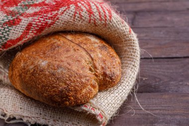 Ahşap arka plan üzerinde bir zanaat ekmek. Yakın çekim.