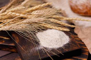 Spikelets ve un closeup ahşap tahta ve çuval bezi. Sağlıklı gıda ve geleneksel ekmek kavramı. Rustik.