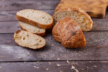 Taze ekmek yakın çekim karanlık bir arka plan üzerine dilimlenmiş. Sağlıklı gıda ve geleneksel ekmek kavramı. Rustik.