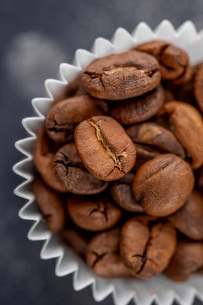 Coffee beans in the package from candy on a dark background. Close-up. Top view.