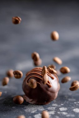 Kahve çekirdekleri el yapımı şeker düşmek. Karanlık bir arka plan üzerinde doldurma kahve ile Kraft elite şeker. Makro.