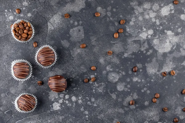 Conjunto de caramelos de chocolate de lujo con relleno de café decorado con salpicaduras de caramelo. Exclusivos bombones hechos a mano sobre fondo de madera. Vista superior . — Foto de Stock