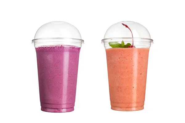Lezzetli meyve smoothies plastik bardak, beyaz bir arka plan üzerinde. Yabani çilek ve kiraz tadı ile iki kokteyller.