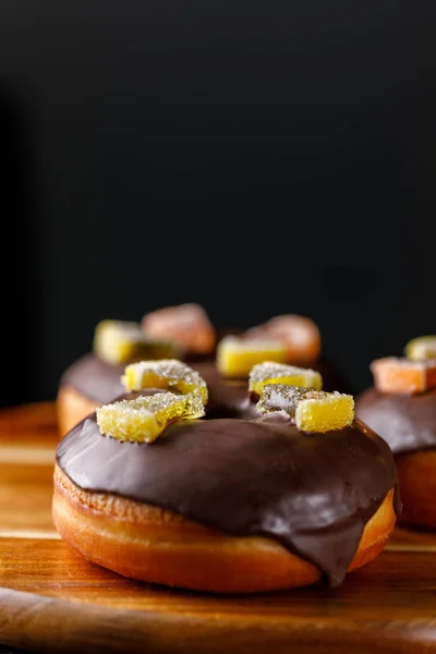 Concetto di cottura, cottura al forno e cibo - primo piano. Ciambelle ricoperte di cioccolato decorate con marmellata . — Foto Stock