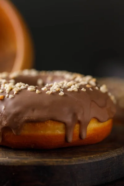 Concetto di cottura, cottura al forno e cibo - primo piano. Ciambella ricoperta di cioccolato al latte su tavola decorativa . — Foto Stock