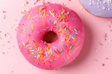 Kavramı, pişirme, pişirme ve gıda - yakın çekim. Çörek, pembe bir arka plan üzerinde pembe bir sır. Eğilim renk.