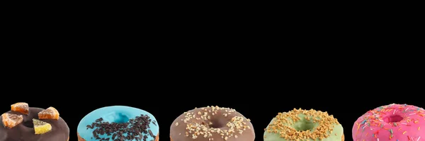 Donuts apetitosos com cobertura multi-colorida em um fundo preto. Isolado. Banner . — Fotografia de Stock