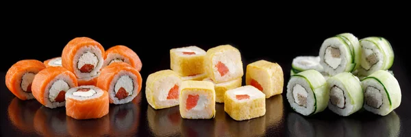 Um clássico rolo de sushi. Sushi em fundo preto.Sushi de frutos do mar japonês, sushi um fundo preto . — Fotografia de Stock