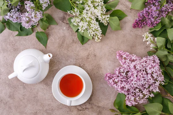 Tea set and flower decor on a textural background. Textural background with flowers and tea pair and place under the text. View from above. Flat lay. The concept of tea drinking.