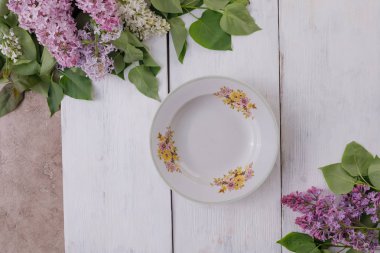 Beyaz boyalı bir arka plan üzerinde bir tabak ve çiçek bir dekor 